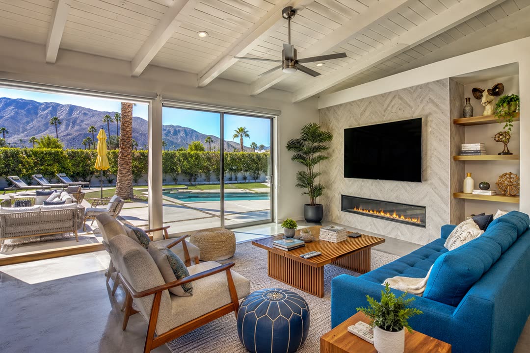 The same living room after editing: the mountains and pool read clearly through the glass while the room keeps its light.